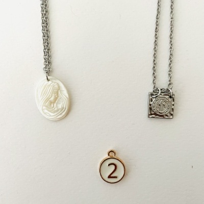 Colares com pendentes e medalha número 2 em fundo branco