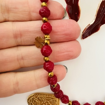 Pulseira vermelha com contas facetadas, contas douradas, pingente em forma de coração e trevo