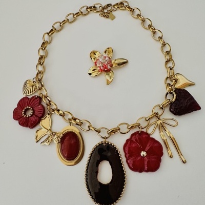 Colar dourado com vários pendentes coloridos sobre fundo branco