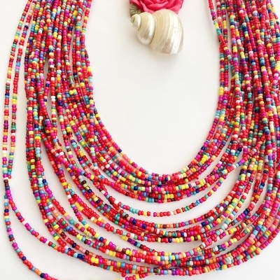 Colar colorido com contas pequenas e broche de flor rosa com concha