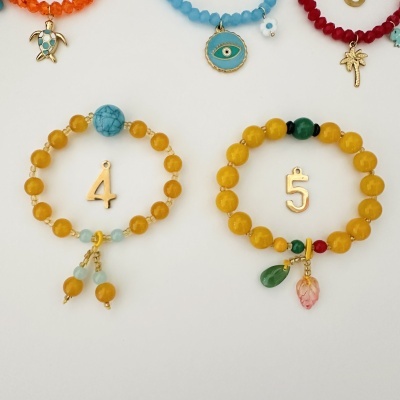 Pulseiras coloridas com contas e pingentes de números e símbolos