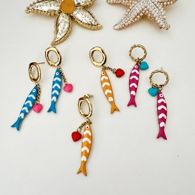 Brincos com peixes coloridos e corações pendurados em argolas douradas
