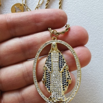 Colar dourado com pendente oval religioso decorado com pedras brancas e pretas