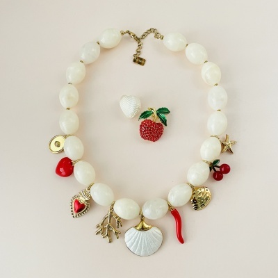 Colar com contas brancas e vários pendentes coloridos sobre fundo claro
