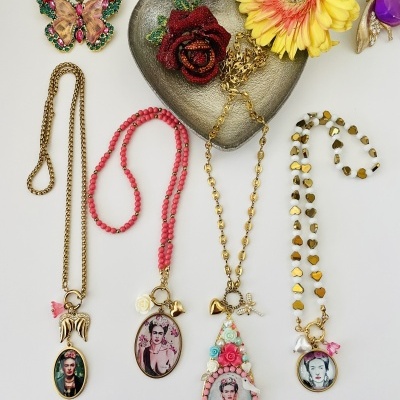 Quatro colares com pendentes ovais de Frida Kahlo, broche borboleta colorido, flor amarela e prato coração cinzento