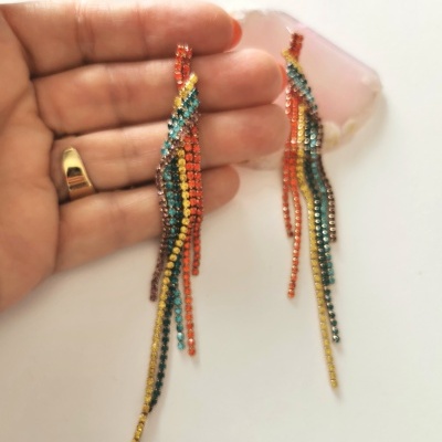 Brincos coloridos com franjas brilhantes em várias cores