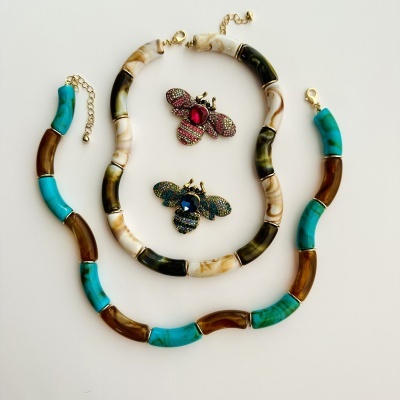 Colares com contas de resina coloridas e dois broches de abelha coloridos