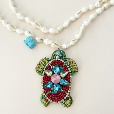 Colar com pendente de tartaruga em pedrarias coloridas e corrente branca de nós.