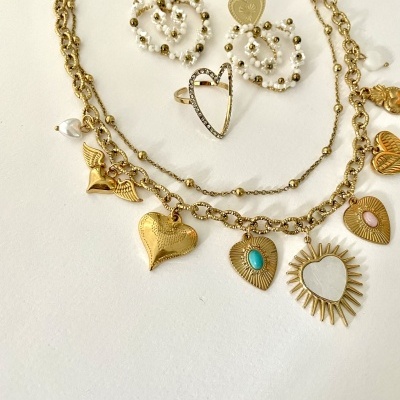 Conjunto de bijuteria dourada com colares, brincos e anel em formas de coração e pérolas