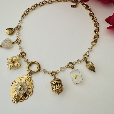 Colar dourado com pendentes variados e madrepérola em fundo branco