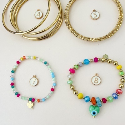 Pulseiras douradas e coloridas numeradas sobre fundo branco