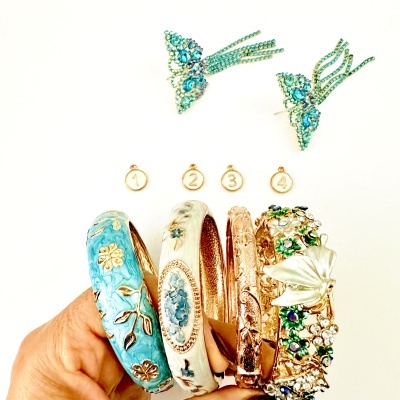 Pulseiras coloridas decoradas com flores e brincos borboleta azuis com strass