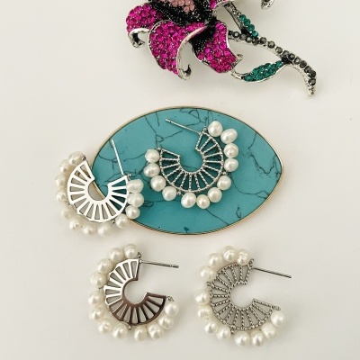 Broche flor cristais rosa e brincos pérolas sobre base azul turquesa