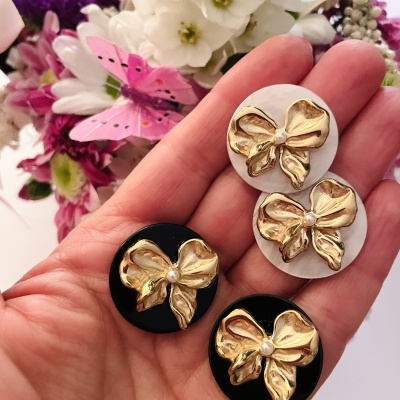 Colares redondos com laços dourados e pérolas no centro