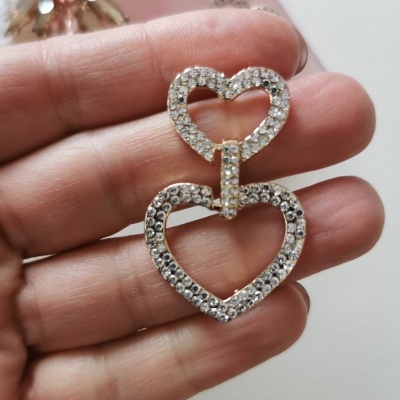 Brinco dourado com pedras em forma de dois corações