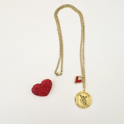 Colar dourado com medalhão redondo e dois corações vermelhos