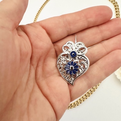 Colar com pingente em forma de flor e coração em metal prateado com detalhe azul e corrente dourada
