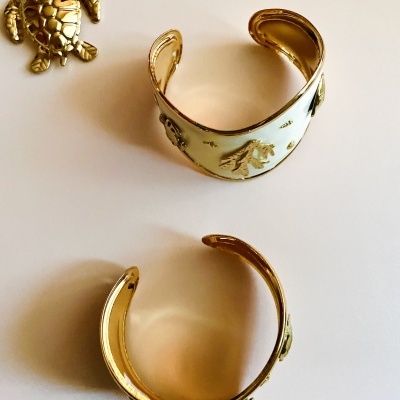 Pulseiras douradas esmaltadas com desenhos de tartarugas e pendente de tartaruga dourado