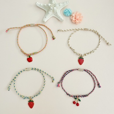 Quatro pulseiras trançadas com pendentes de frutas e decoração marinha