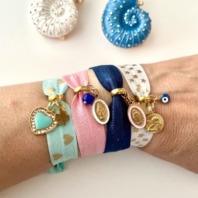 Pulseiras coloridas de tecido com pendentes dourados e brincos em forma de concha azul e branca