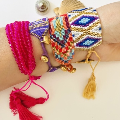 Pulseiras coloridas de contas em pulsos com decoração de conchas