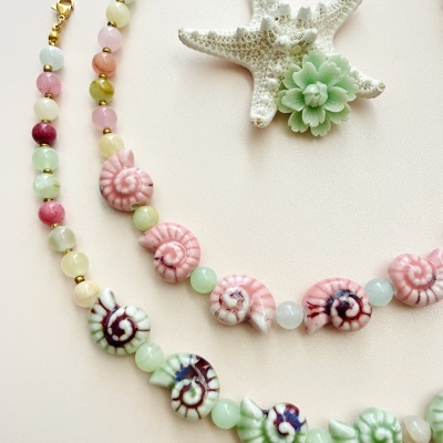 Colares coloridos com figuras de conchas e estrela-do-mar branca com flor verde