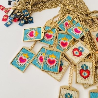 Colares com pendentes retangulares bordados, padrões de corações coloridos.