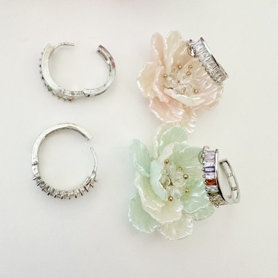 Brincos de argola prateados com pedras coloridas e flores decorativas pastel