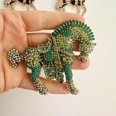 Broche em forma de cavalo com pedras verdes e azuis, detalhes dourados