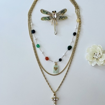 Conjunto de colares dourados com pingentes coloridos e broche de libélula esmaltada