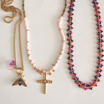 Três colares com pendentes variados sobre fundo branco