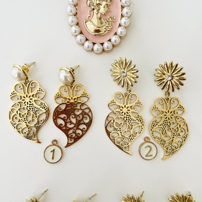Brincos dourados com filigrana, pérolas e broche rosa com figura feminina dourada