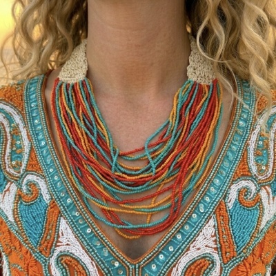 Colar colorido de contas com fecho de crochê e blusa bordada colorida