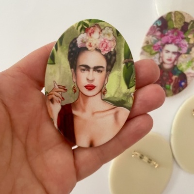 Broche oval com imagem de Frida Kahlo e flores na cabeça
