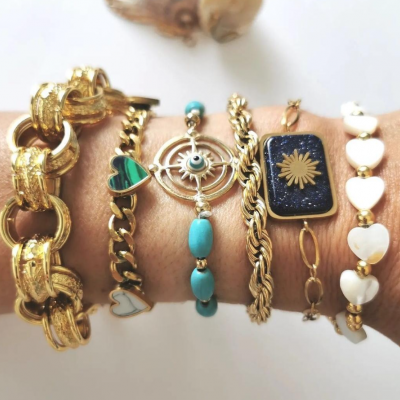 Pulseiras douradas e coloridas com detalhes em coração e turquesa num pulso