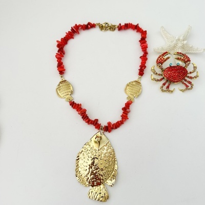Colar vermelho com pendentes dourados em forma de peixe e broche caranguejo com pedras vermelhas