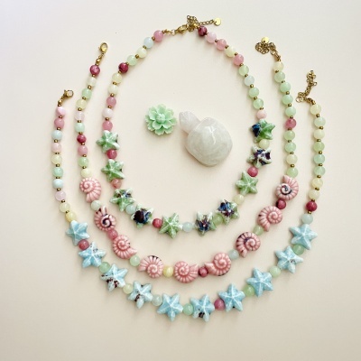 Conjunto de colares e pulseiras coloridas com motivos marítimos em fundo claro