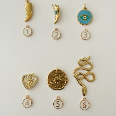 Seis pendentes dourados numerados de 1 a 6 com vários formatos sobre fundo branco
