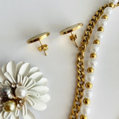 Brincos dourados, pulseira com pérolas e correntes douradas, broche de flor branca com pérolas