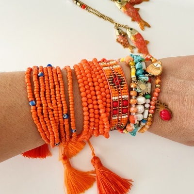 Conjunto de pulseiras coloridas em contas e metais num pulso
