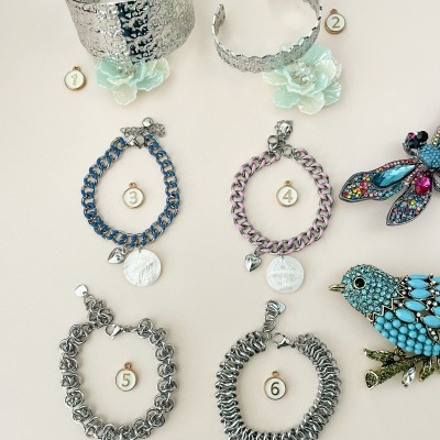 pulseiras metálicas e decorativas numeradas com broches coloridos de pássaro e libélula