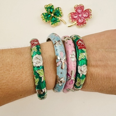 Pulseiras decoradas e broches de trevo coloridos em fundo branco