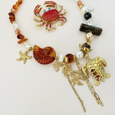 Colar com concha, estrela do mar, tartaruga e caranguejo com contas e pedras várias