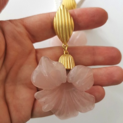 Brinco dourado com flor rosa translúcida e superfície estriada