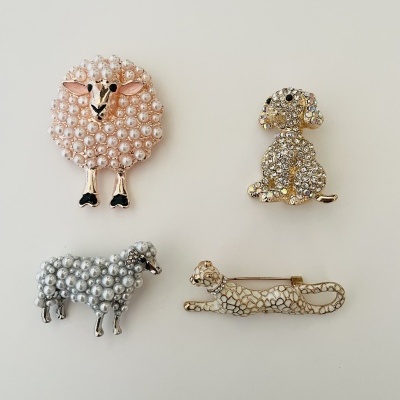 Quatro broches de animais decorativos em várias cores e texturas