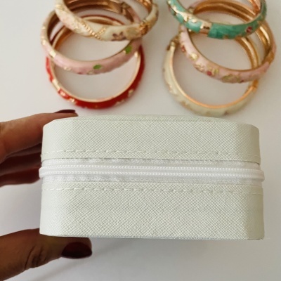 Pulseiras florais coloridas e caixa de tecido branco com fecho