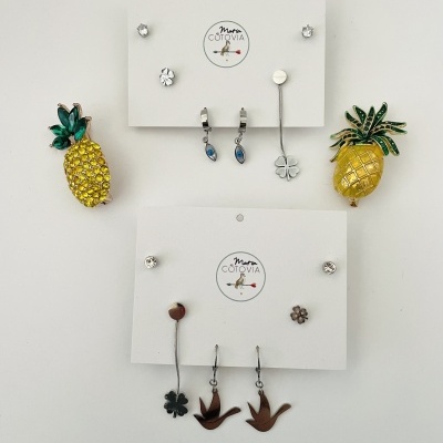 Conjuntos de brincos em cartões brancos com texto Maria Cotovia, vários estilos e cores, fundo branco