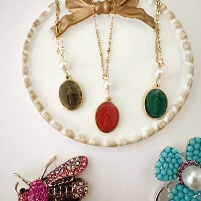 Colares com pingentes ovais coloridos e broches decorativos em fundo branco