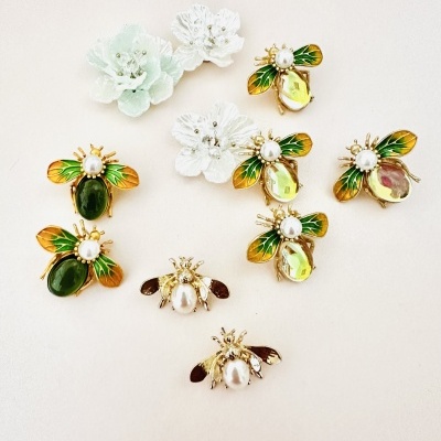 Pins decorativos de abelhas e flores em fundo claro