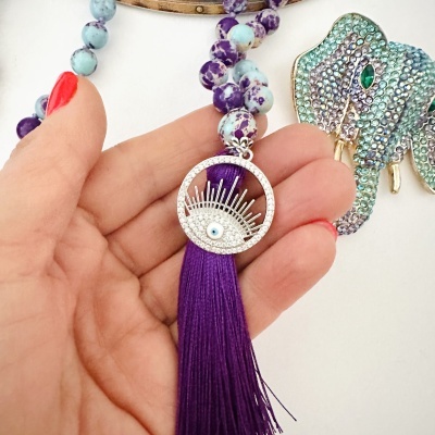 Colar com contas roxas e azuis e pendente com olho e franja roxa